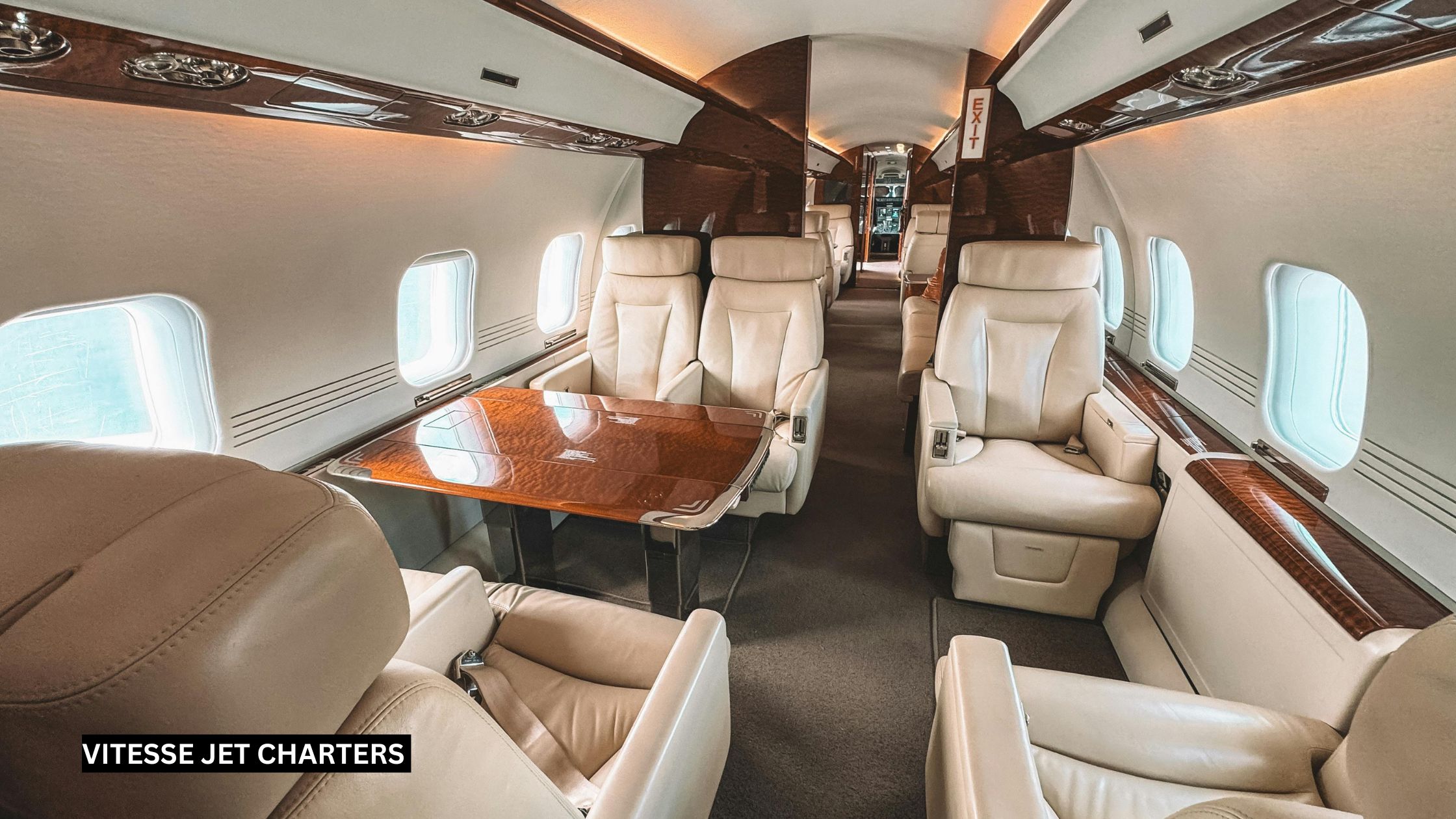 Spacious empty interior of a large private jet cabin, featuring wide leather seating, panoramic windows, and premium finishes ready for group sports team travel.